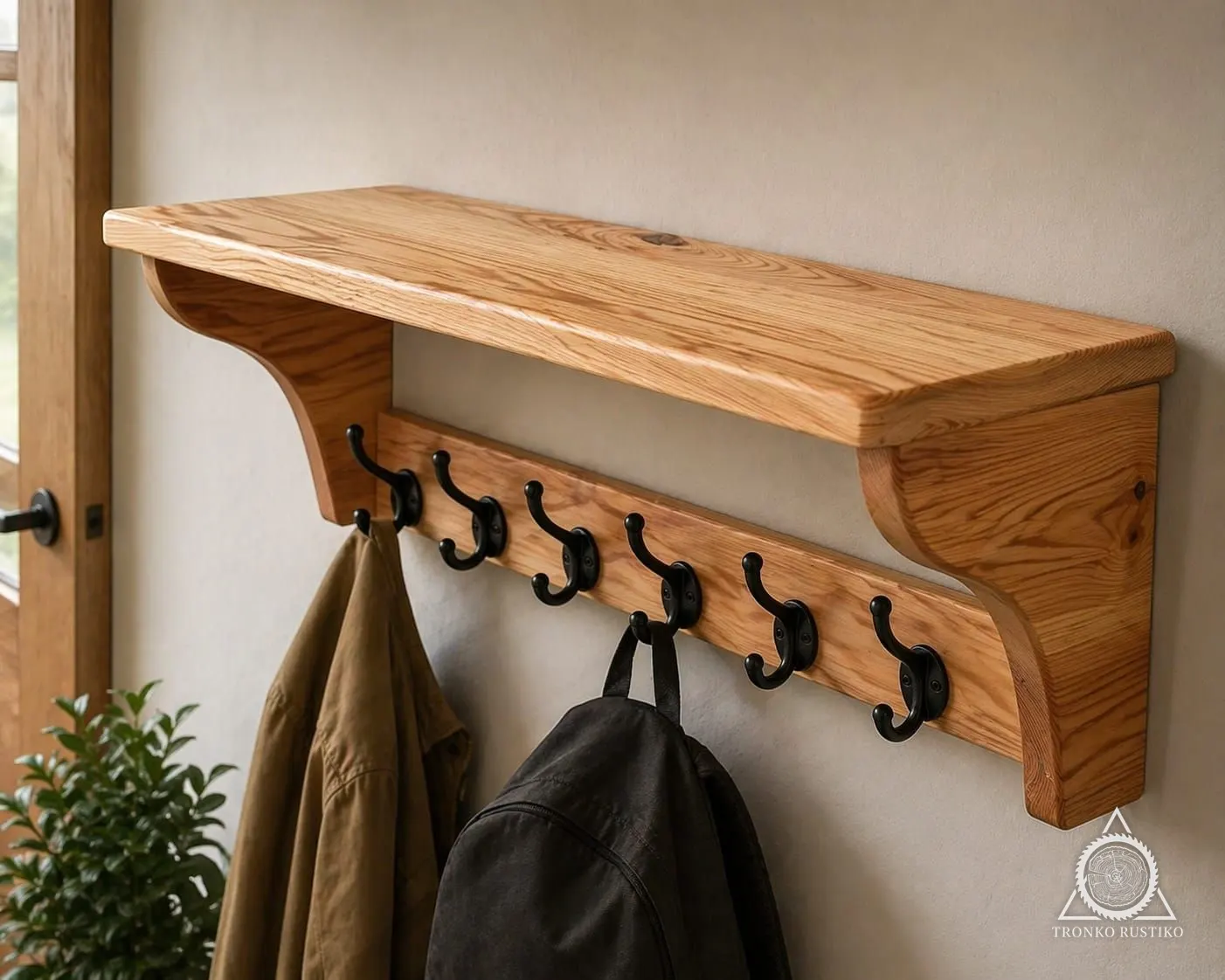 Perchero de muro de madera con repisa superior y seis ganchos metálicos negros.