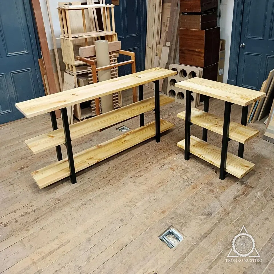 Dos arrimos de madera clara con estructura metálica negra y repisas, en el taller.