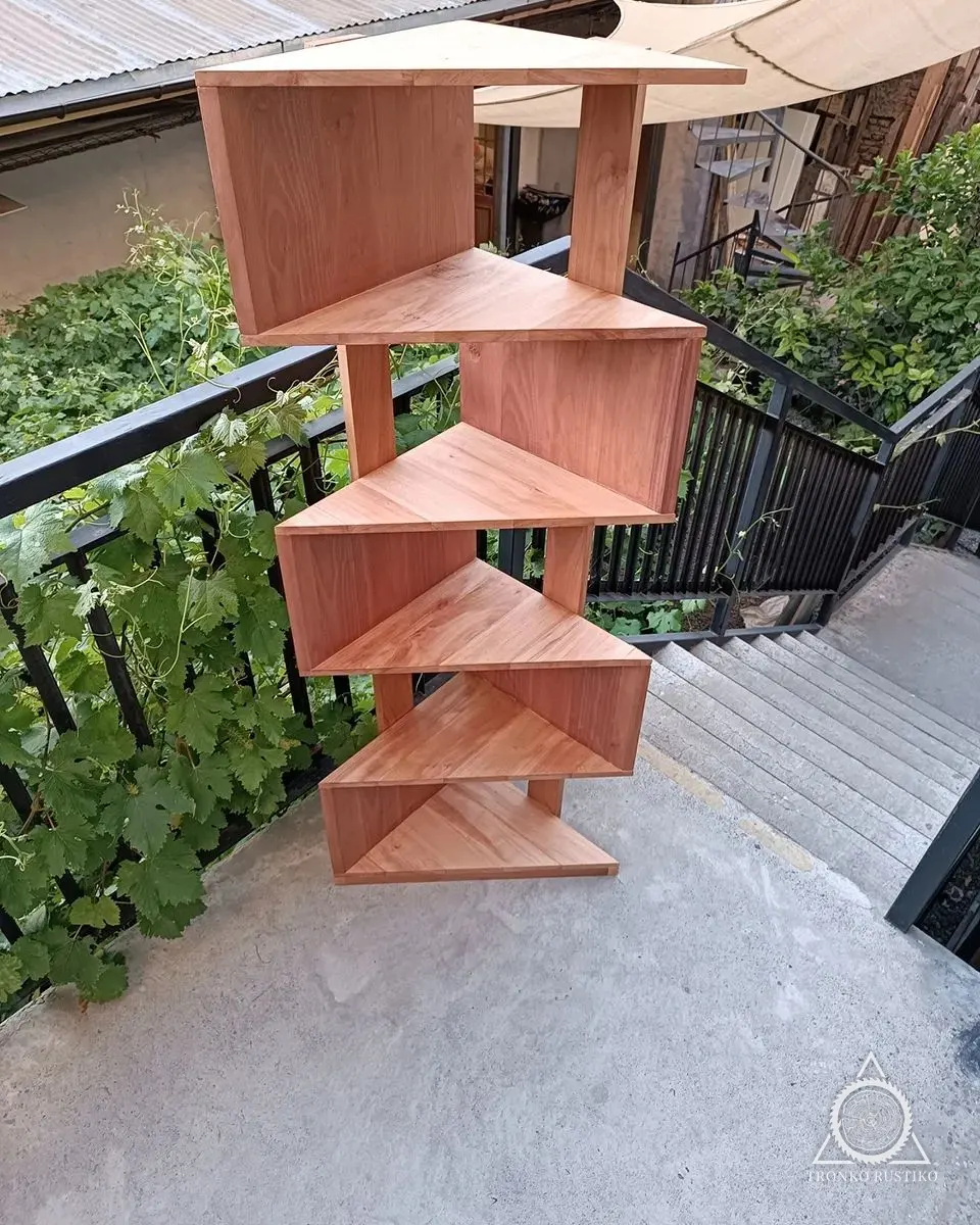 Repisa esquinera de madera de varios niveles, en una terraza con plantas.